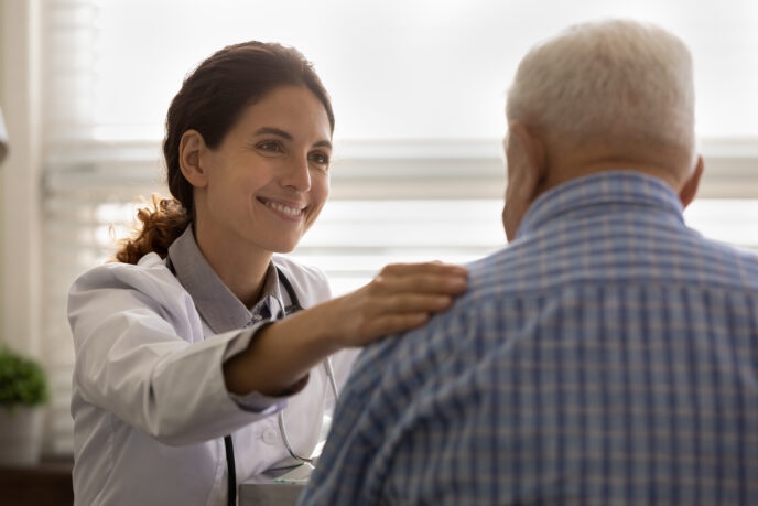 Smiling female doctor support old male