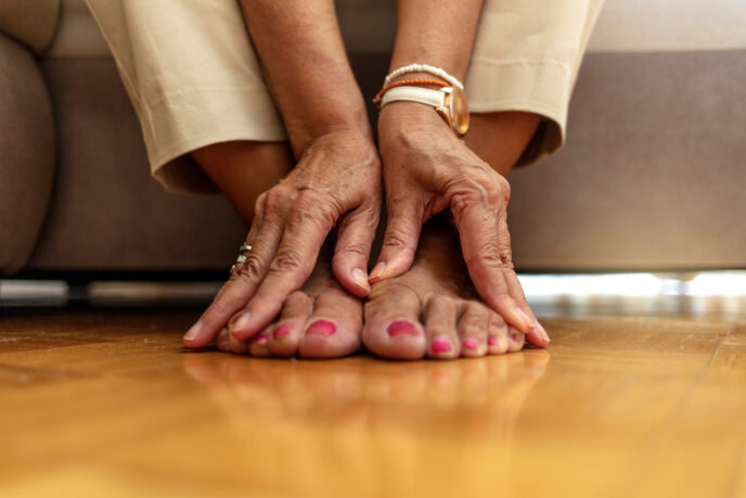 senior woman hands touching legs